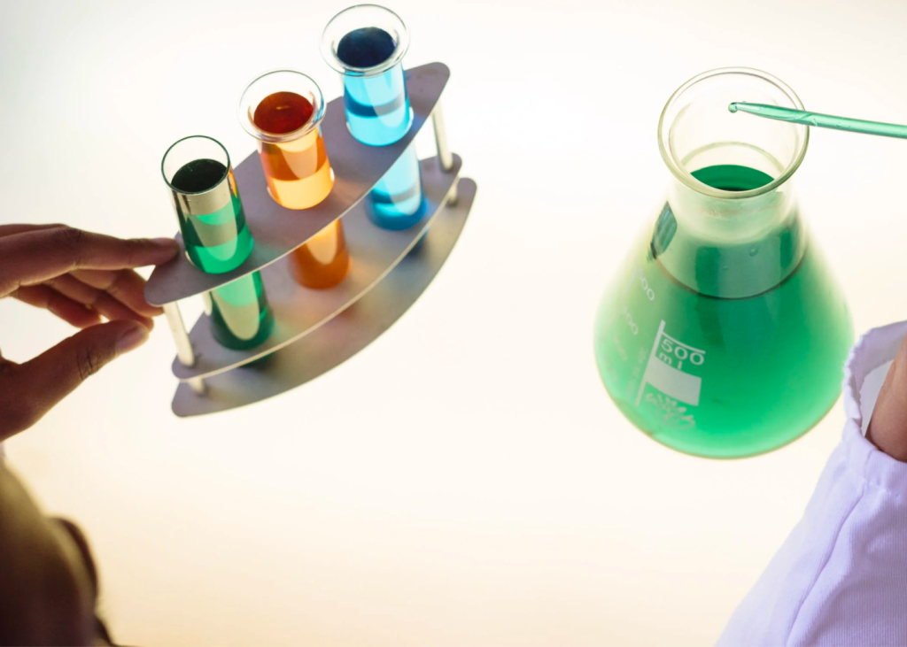 A beaker, pipettes, and test tubes containing liquids in a lab.