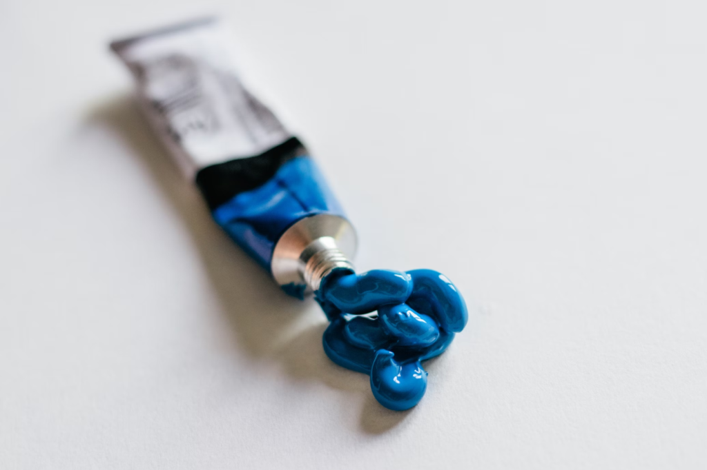 A photo showing a tube releasing blue paint.