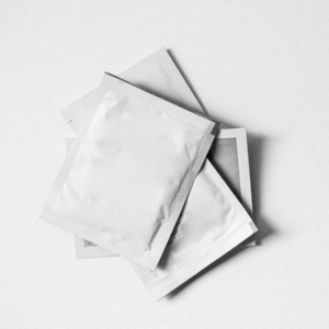 A photo showing white sachets resting on a white surface.