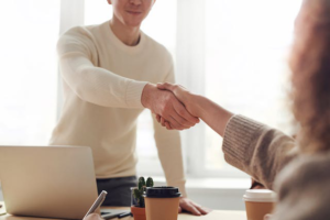 An individual shaking hands with a representative of a contract packaging company