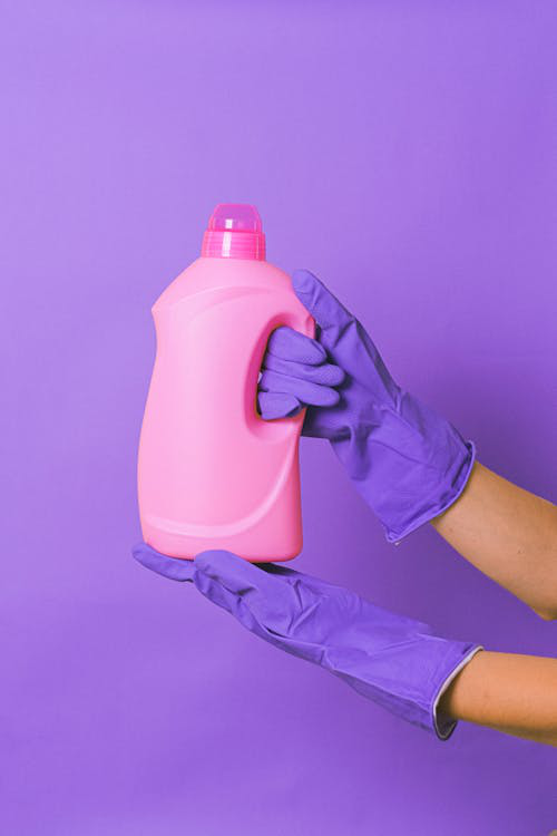 Person holding a bottle of household liquid