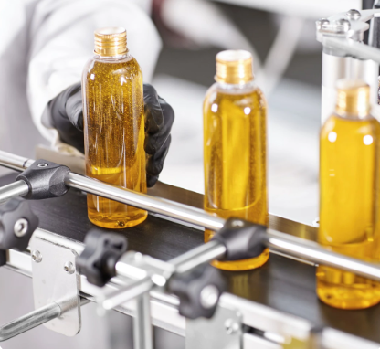 Couple of bottles being filled with liquid.