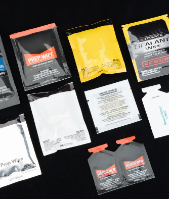 Colorful pouches filled with chemicals laid out on a black background.